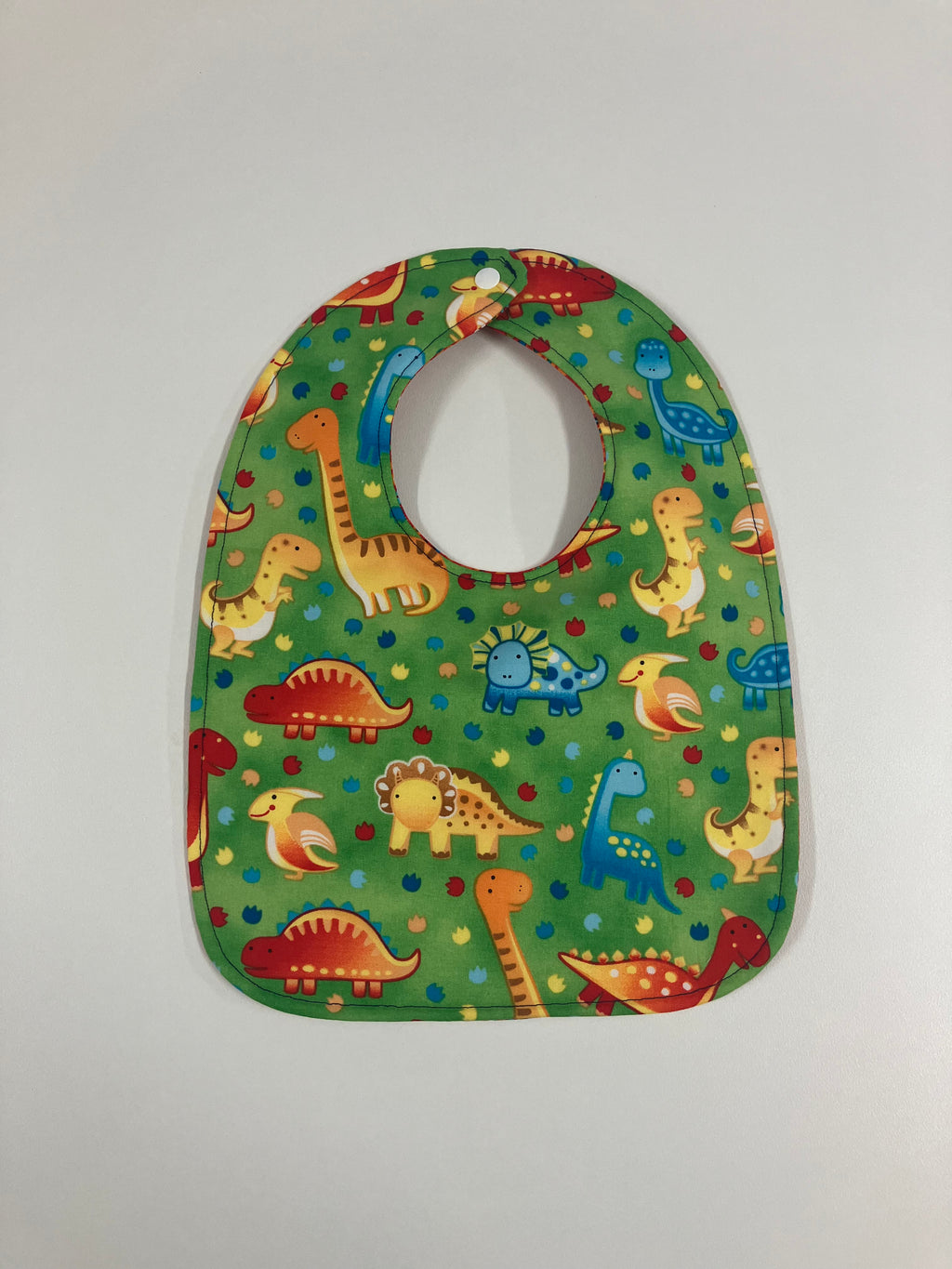 Reversible Bib – Green Dinosaurs / Red with Spots